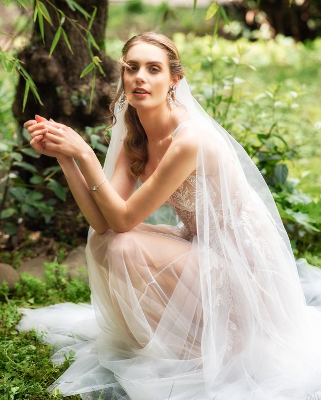 ethereal wedding dress woman kneeling in garden